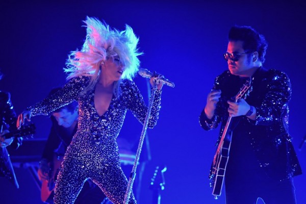 Lady Gaga con sus premios y durante su actuación (AFP)