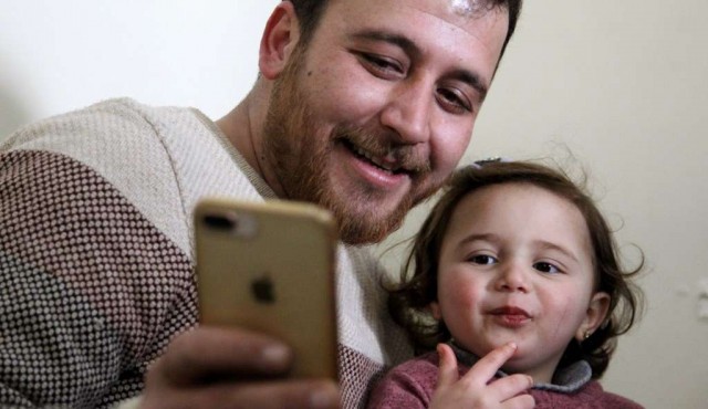 Siria: padre enseña a su hija a reirse de las bombas, “a la espera de una vida decente”